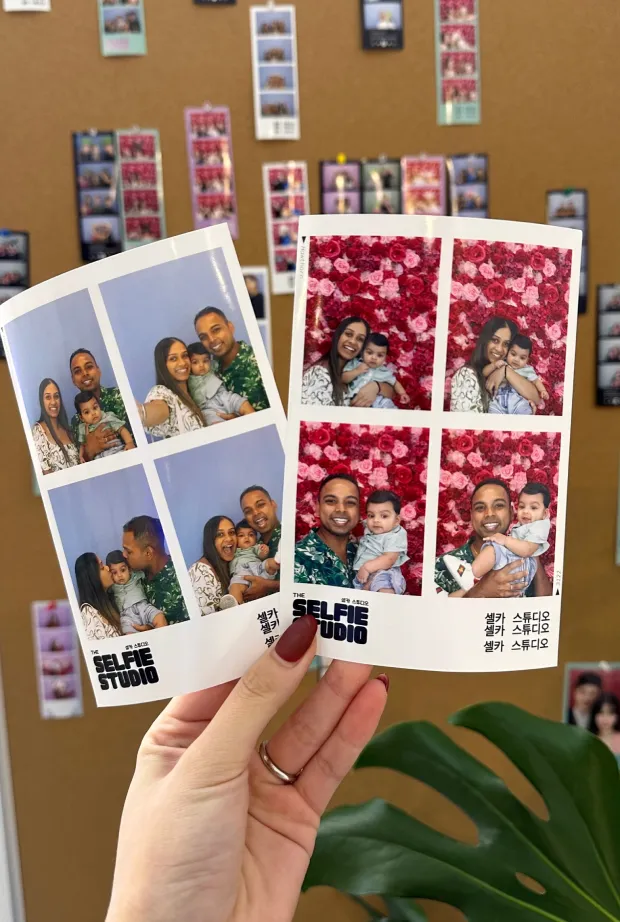 A hand holding two photo strips