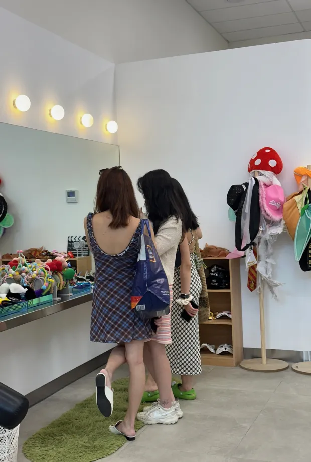Three women standing in front of a mirror