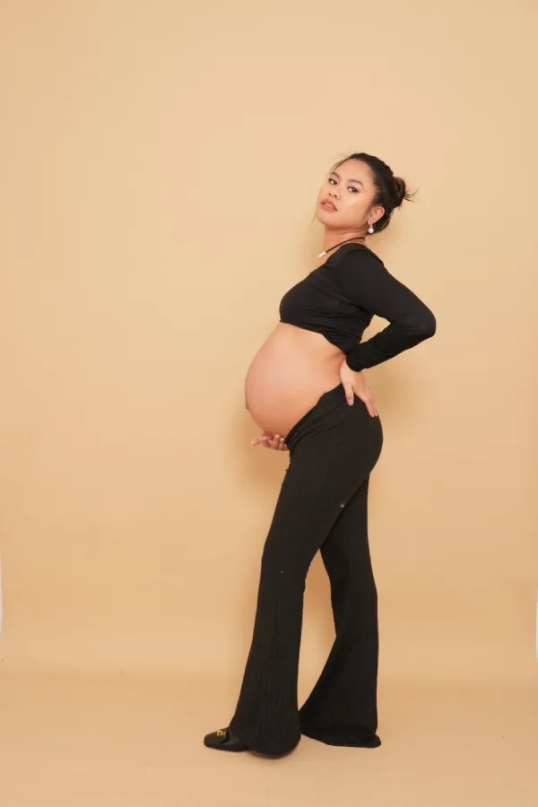 A pregnant woman posing in profile