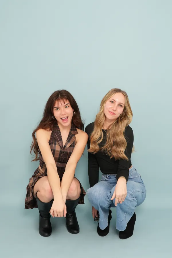 Two women crouching and smiling